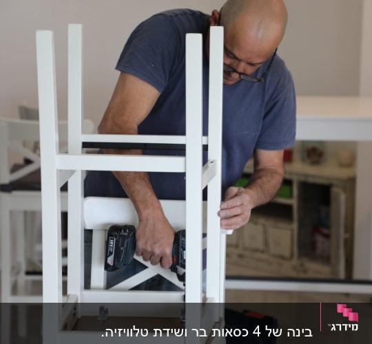 אדם מרכיב כיסא בעזרת מברגה חשמלית